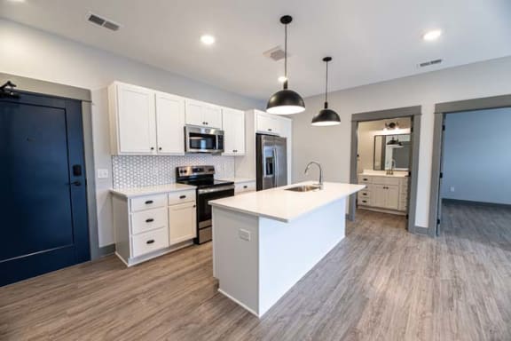 a large white kitchen with a white counter top at The Commons at Rivertown, Grandville, MI