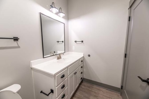 a bathroom with a white sink and a mirror at The Commons at Rivertown, Grandville, MI, 49418