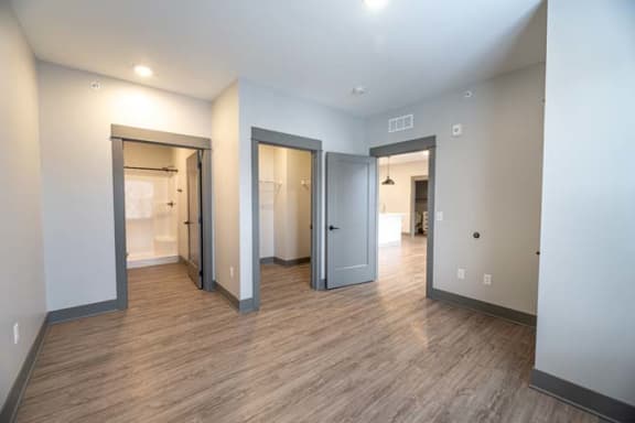 a empty living room with a wood floor and doors at The Commons at Rivertown, Michigan, 49418