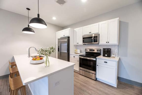 a kitchen with white cabinets and a white counter top at The Commons at Rivertown, Grandville, 49418