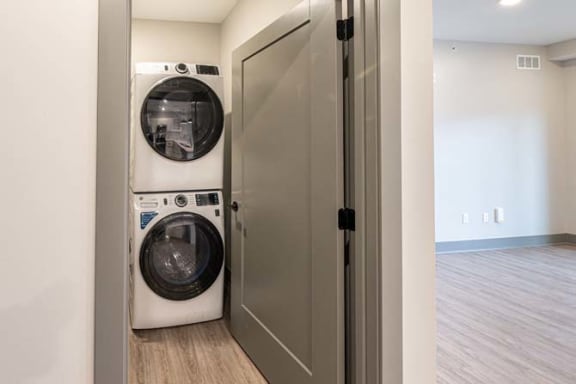 a white washer and dryer in a small laundry room at The Commons at Rivertown, Grandville, MI