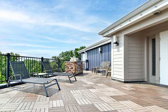 A patio with a table and chairs is surrounded by a black railing.