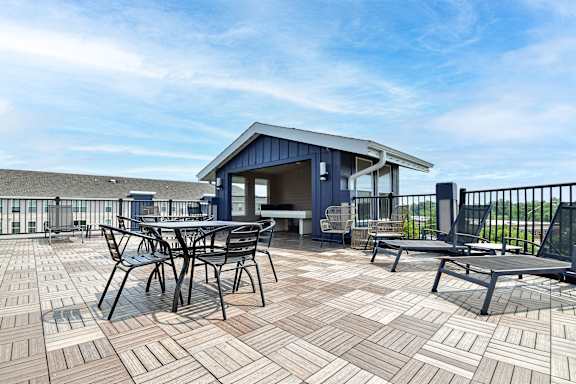 A patio with a table and chairs is set up on a rooftop.
