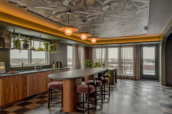 A kitchen with a checkered floor and a bar area.