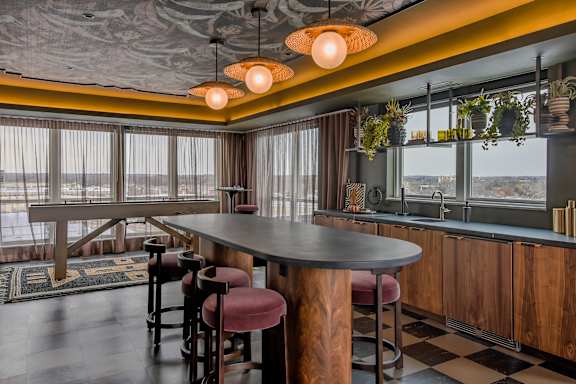 A restaurant with a long table and chairs with a view of the water.