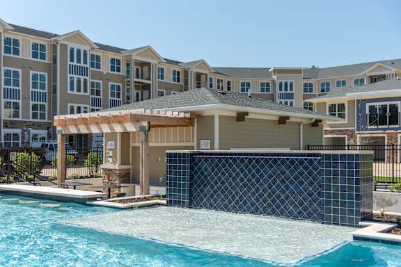 a large swimming pool with a gazebo in front of an apartment building at The Bend Arbordale, Virginia