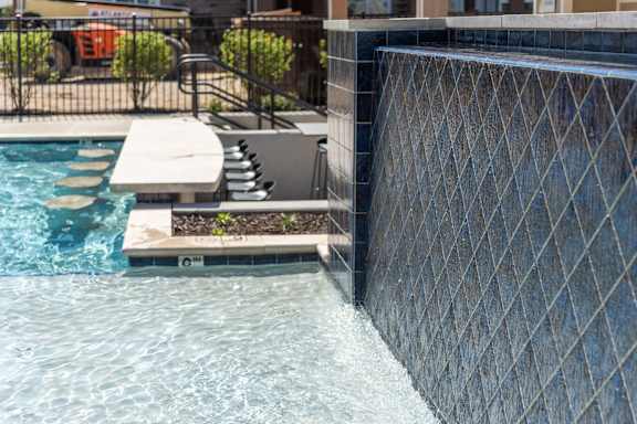 a swimming pool with a retaining wall and a water feature at The Bend Arbordale, Virginia