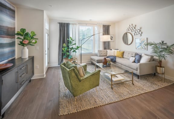 A living room with a green chair and a white couch at Parc at Princeton Junction Apartments, New Jersey, 08540