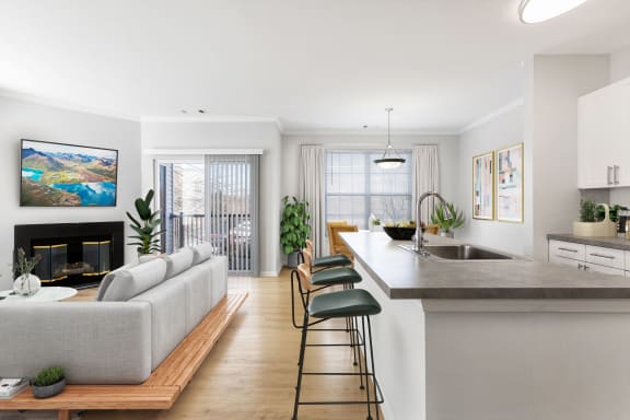 kitchen and living room space with island, grey couch and gas fireplace