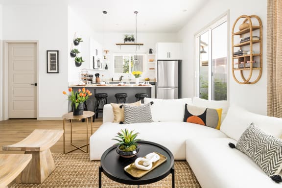 a living room with a white couch and a kitchen in the background at Onyx at Westgate Apartments, Arizona