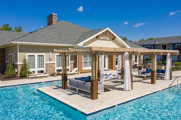 a pergola over a swimming pool in front of a house at The Bend Arbordale, Williamsburg, VA, 23188