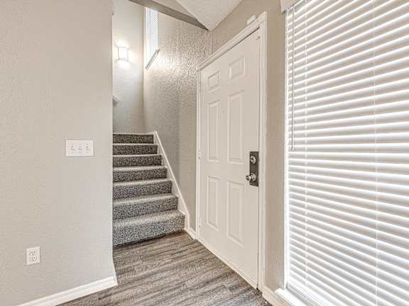 the entryway of a home with stairs and a white door at Diamond Ridge Townhomes, Oklahoma City