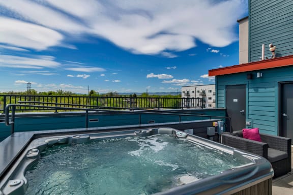 a jacuzzi on the rooftop of a building with a blue sky