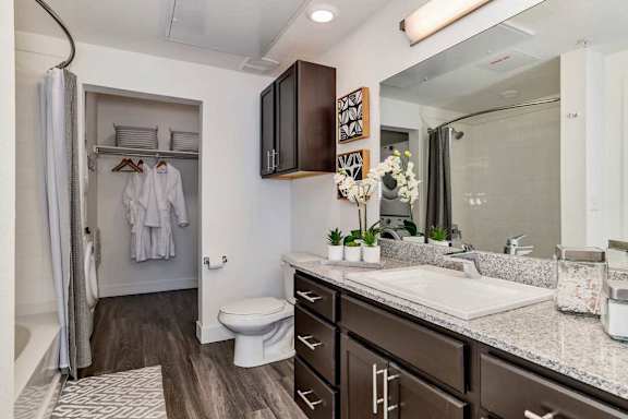 A bathroom with a white toilet, a sink, and a mirror.