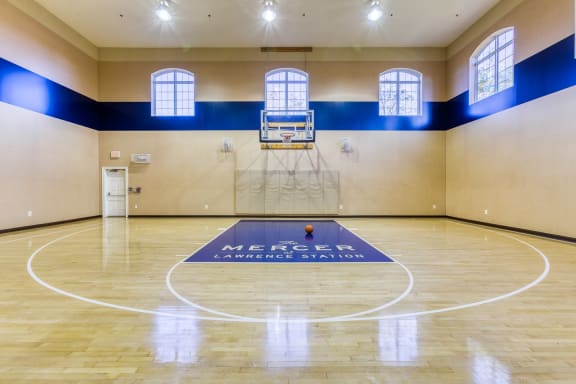interior basketball court with blue and tan floor and white logo