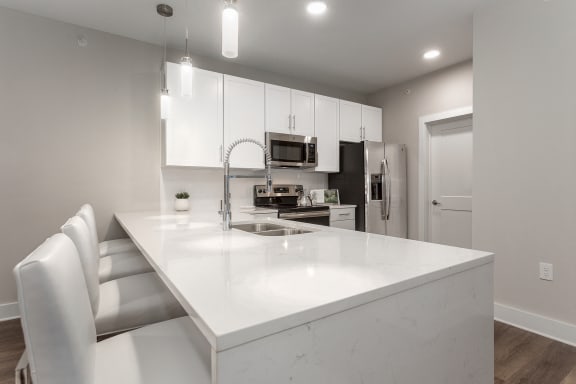 kitchen inside an apartment home with white cabinets, quartz countertops and stainless steel appliances at Annandale Apartment Homes, Murfreesboro, TN