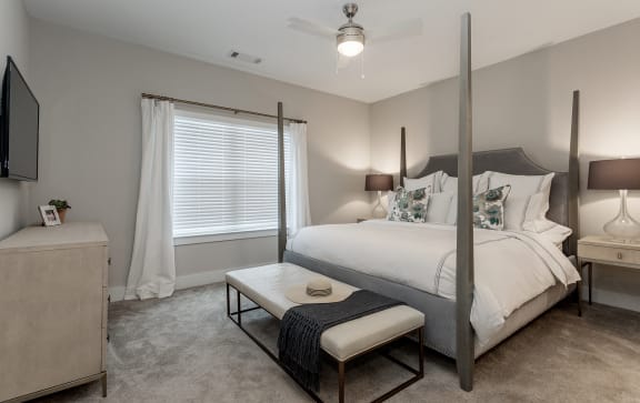 a bedroom with a bed and a table in front of a window at Annandale Apartment Homes, Murfreesboro, 37128