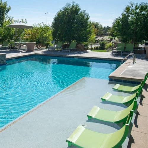 a swimming pool with green chairs at Arterra Place Apartments, Colorado