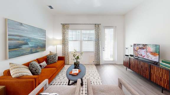 A living room with a couch, a coffee table, and a painting on the wall.