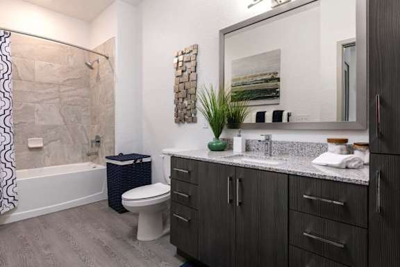 A bathroom with a toilet, sink, and a mirror.