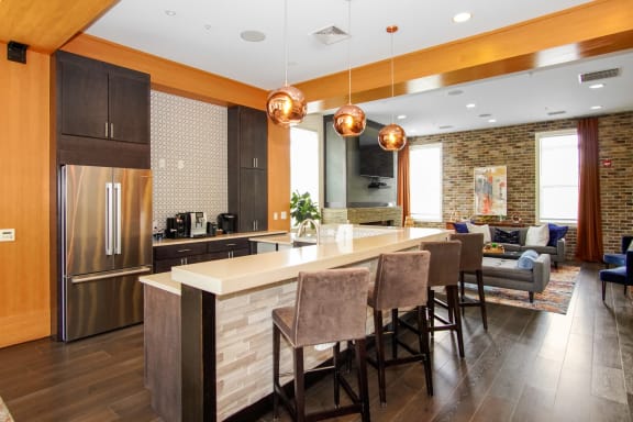 a kitchen with a large center island with a breakfast bar and a living room in the background at The Reserve at Riverdale, Riverdale, NJ