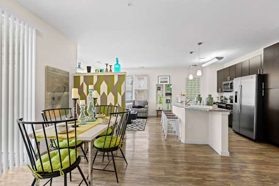 a kitchen and living room with a dining room table and chairs