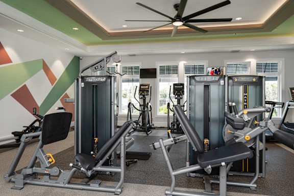 a gym with treadmills and other exercise equipment in a hotel room