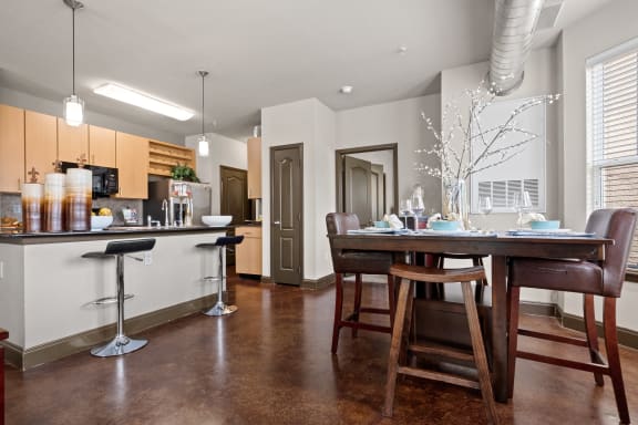 an open kitchen and dining room with a table and chairs at The Millennium Towne Center Apartments, Baton Rouge