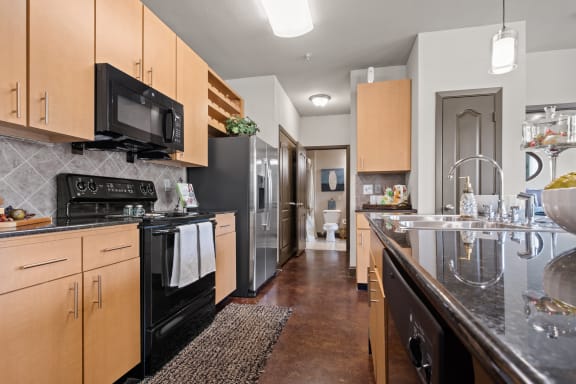 a kitchen with stainless steel appliances and wooden cabinets at The Millennium Towne Center Apartments, Louisiana