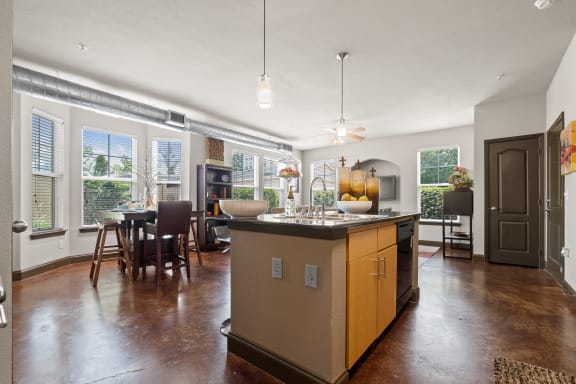 a kitchen with a large island in the middle of a living room at The Millennium Towne Center Apartments, Baton Rouge, LA, 70806