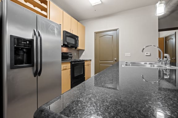 a kitchen with stainless steel appliances and granite counter tops at The Millennium Towne Center Apartments, Louisiana 70806