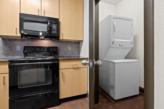 a kitchen with a refrigerator and a stove and a microwave at The Millennium Towne Center Apartments, Louisiana 70806