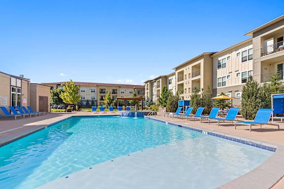 our apartments have a large swimming pool with blue lounge chairs