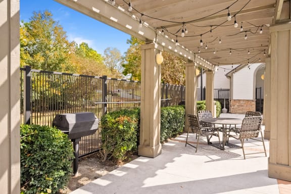 a patio with a table and chairs and a grill  at 150 Summit, Birmingham, AL