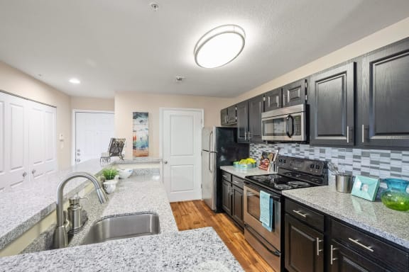 a kitchen with black appliances and granite counter tops  at 150 Summit, Birmingham, 35243