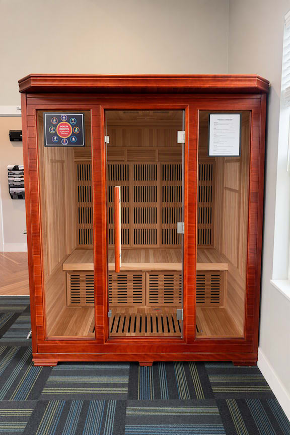 A wooden cabinet with a door open to a shelf.
