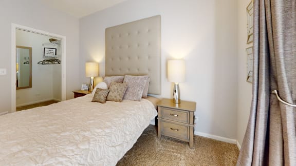 a bedroom with a bed and a nightstand with two lamps
