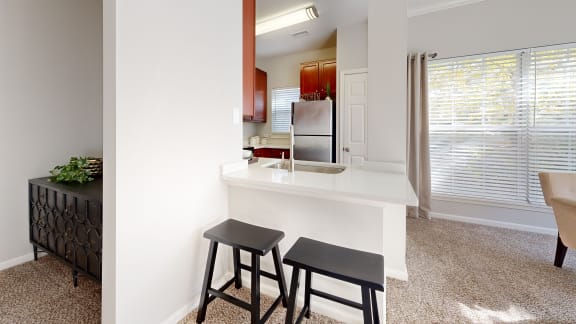 a kitchen with a counter and two stools
