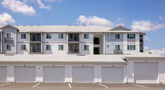 A large white building with multiple garage doors in front.