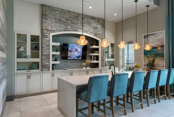 A kitchen with a stone backsplash and a row of blue chairs at The Addison on Long Bayou Apartments, Seminole, Florida