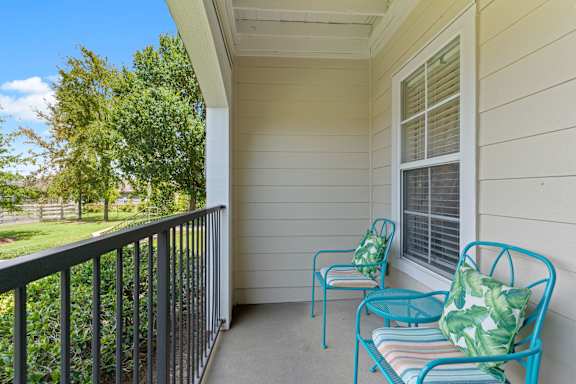 a balcony with two chairs and a table