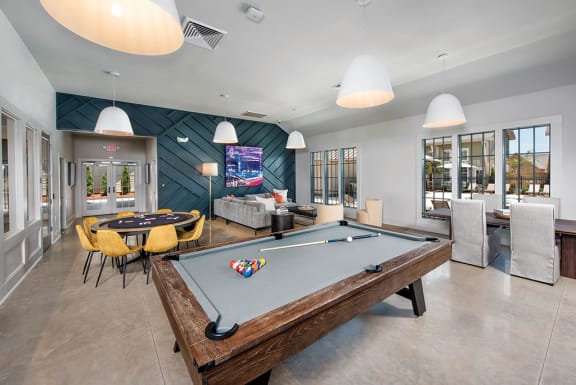 a game room with a pool table and a television at The Cottages at Old Monrovia Apartment , Huntsville, Alabama