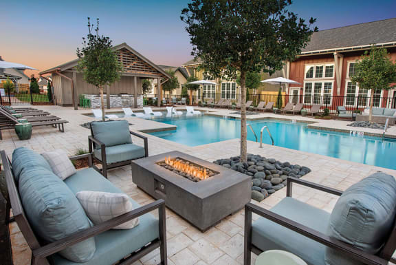 a swimming pool with patio furniture and a fire pit at The Cottages at Old Monrovia Apartment, Huntsville, AL, 35806