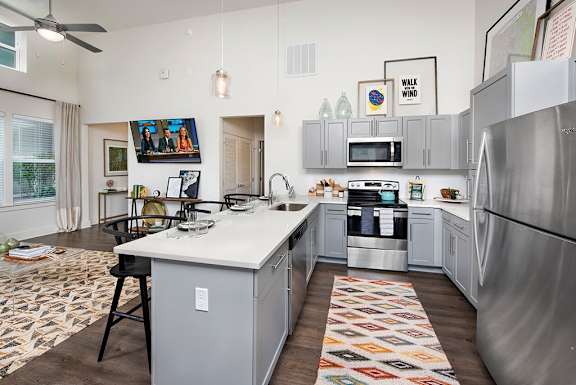 A modern kitchen with a large island and stainless steel appliances at The Cottages at Old Monrovia Apartment , Huntsville, AL