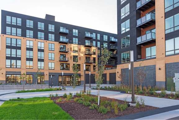 A modern building with a courtyard in front. at The Arlow on Kellog, Minnesota