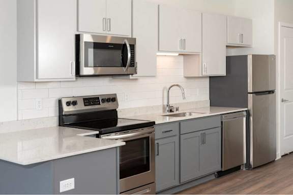 A modern kitchen with a stove, oven, microwave, and refrigerator. at The Arlow on Kellog, St. Paul, MN, 55102