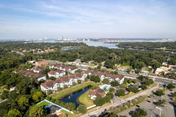 an aerial view of magnolia village with a lake and a city in the background at Magnolia Village Apartments, Florida
