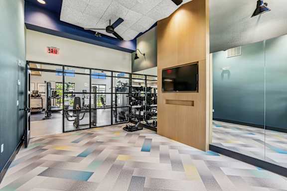 A gym with a variety of equipment at The Arboretum Apartments, Farmingville, 11738