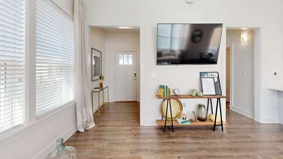 A room with a wooden floor and a white wall with a painting on it at The Cottages at Old Monrovia Apartment , Huntsville