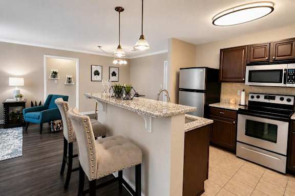 A kitchen with a white island and brown cabinets.